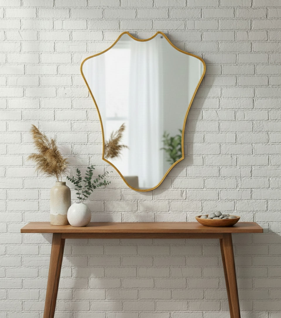 Crowned Curve brass mirror styled above a wooden console table