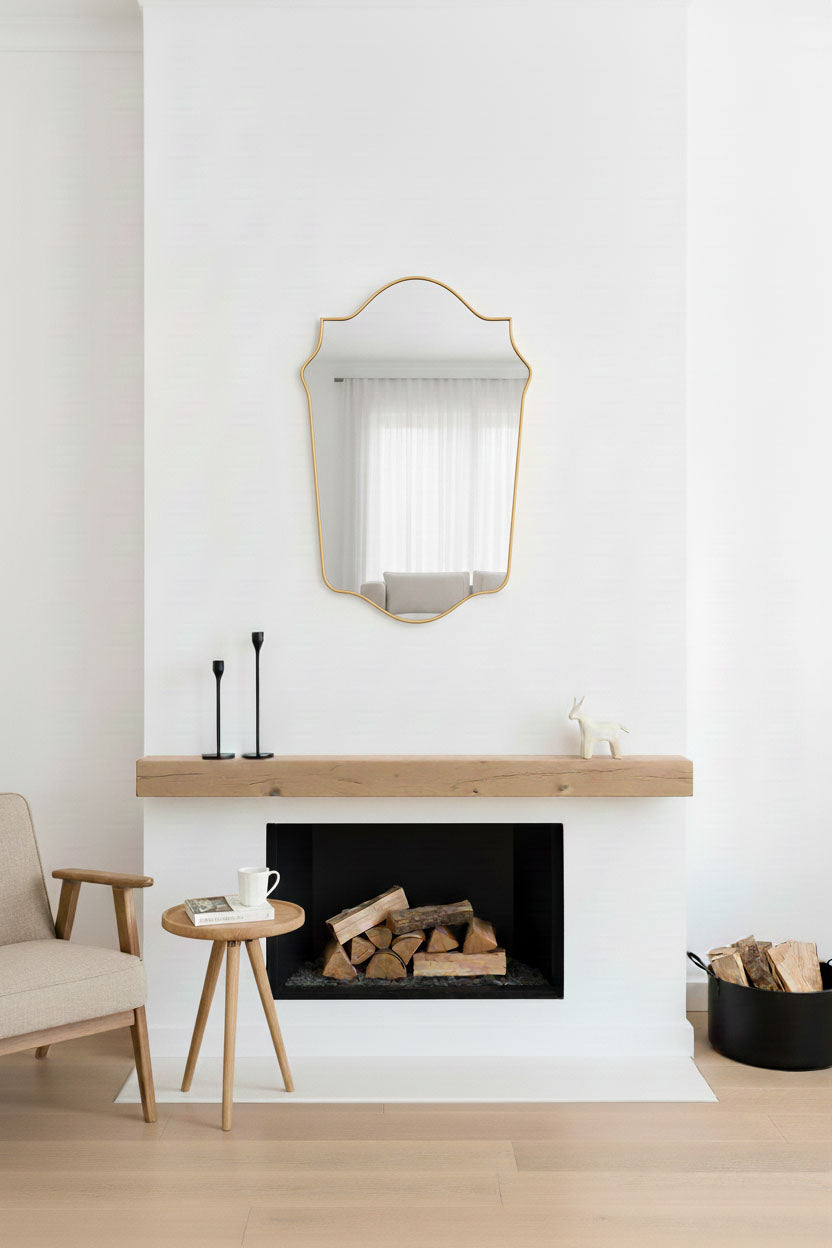 Decorative shield brass mirror above fireplace mantel in modern living room