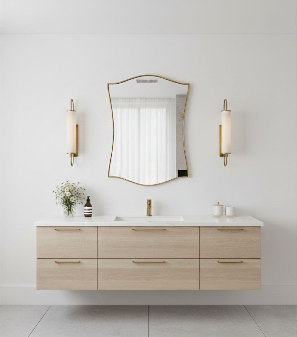 Elegant curved shield mirror with brass frame above floating vanity