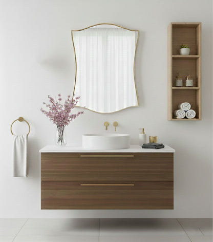 Graceful shield brass mirror styled above modern wooden bathroom vanity