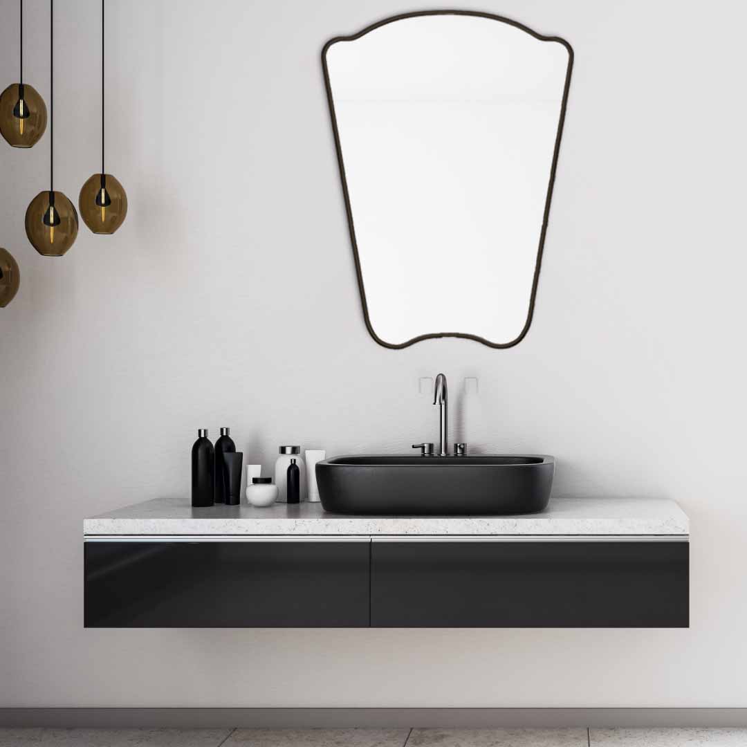 black Irregular Mirror hanging on bathroom  , brass faucet and sink 