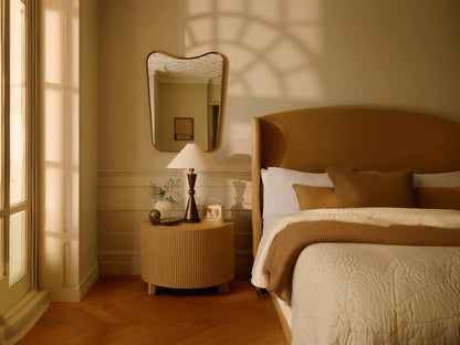 curved brass mirror in bedroom