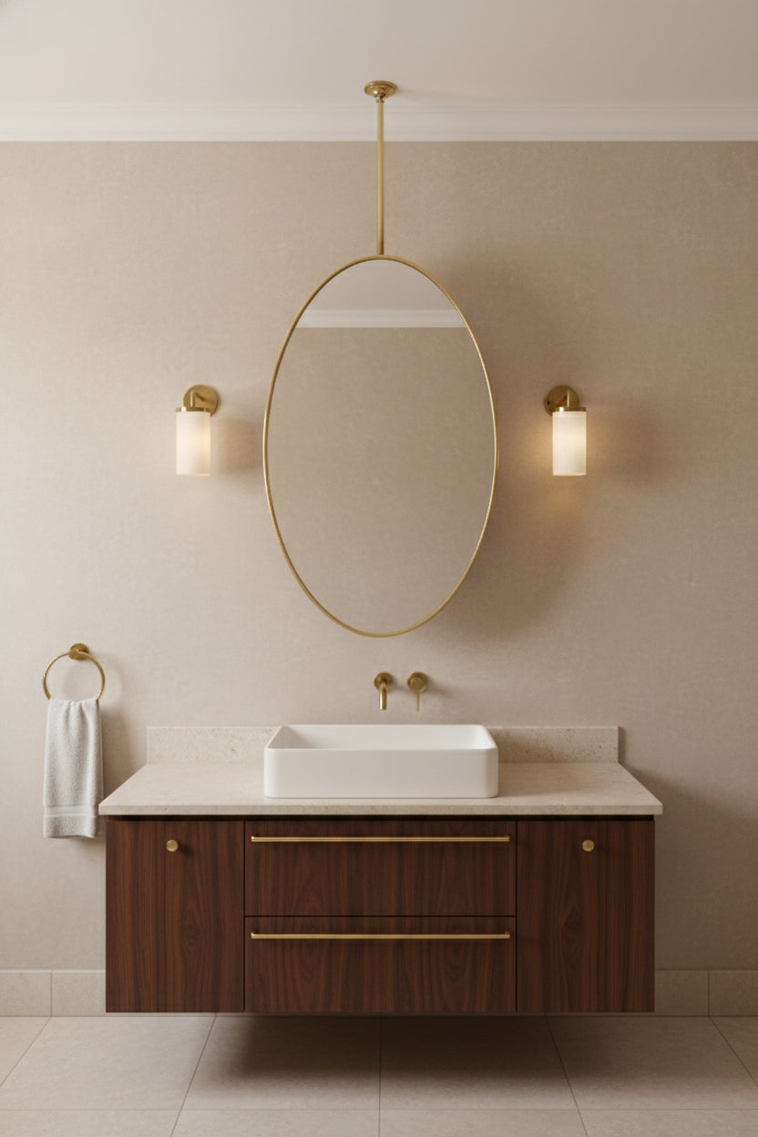 Hanging oval brass mirror over wood vanity