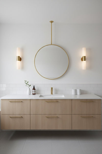 Minimalist bathroom with suspended round brass mirror and wood vanity