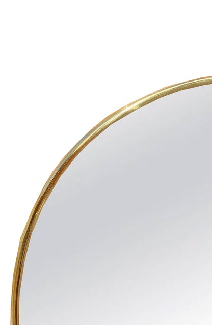 a round mirror with a gold rim on a white background
