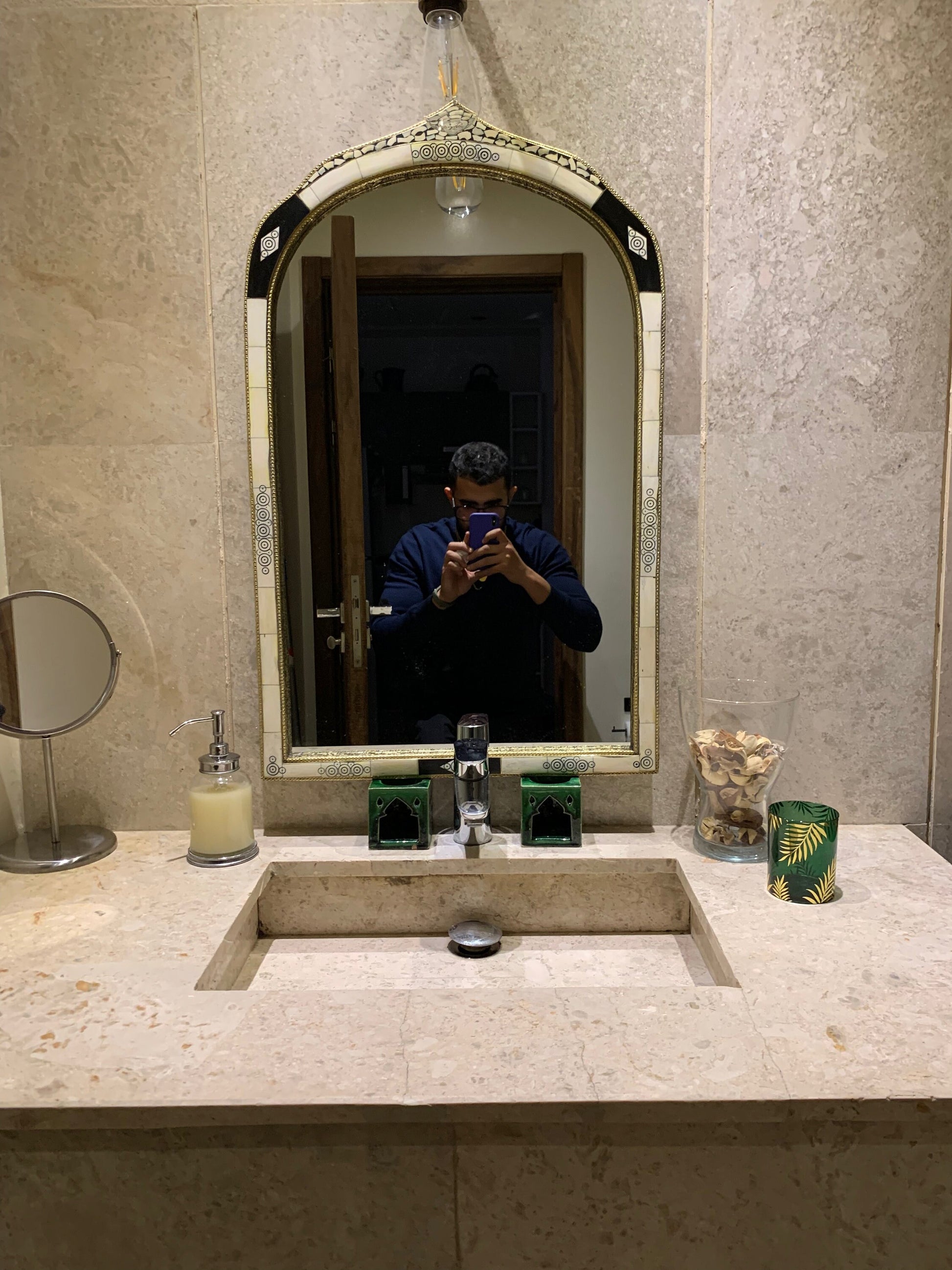 a man taking a picture of himself in a bathroom mirror