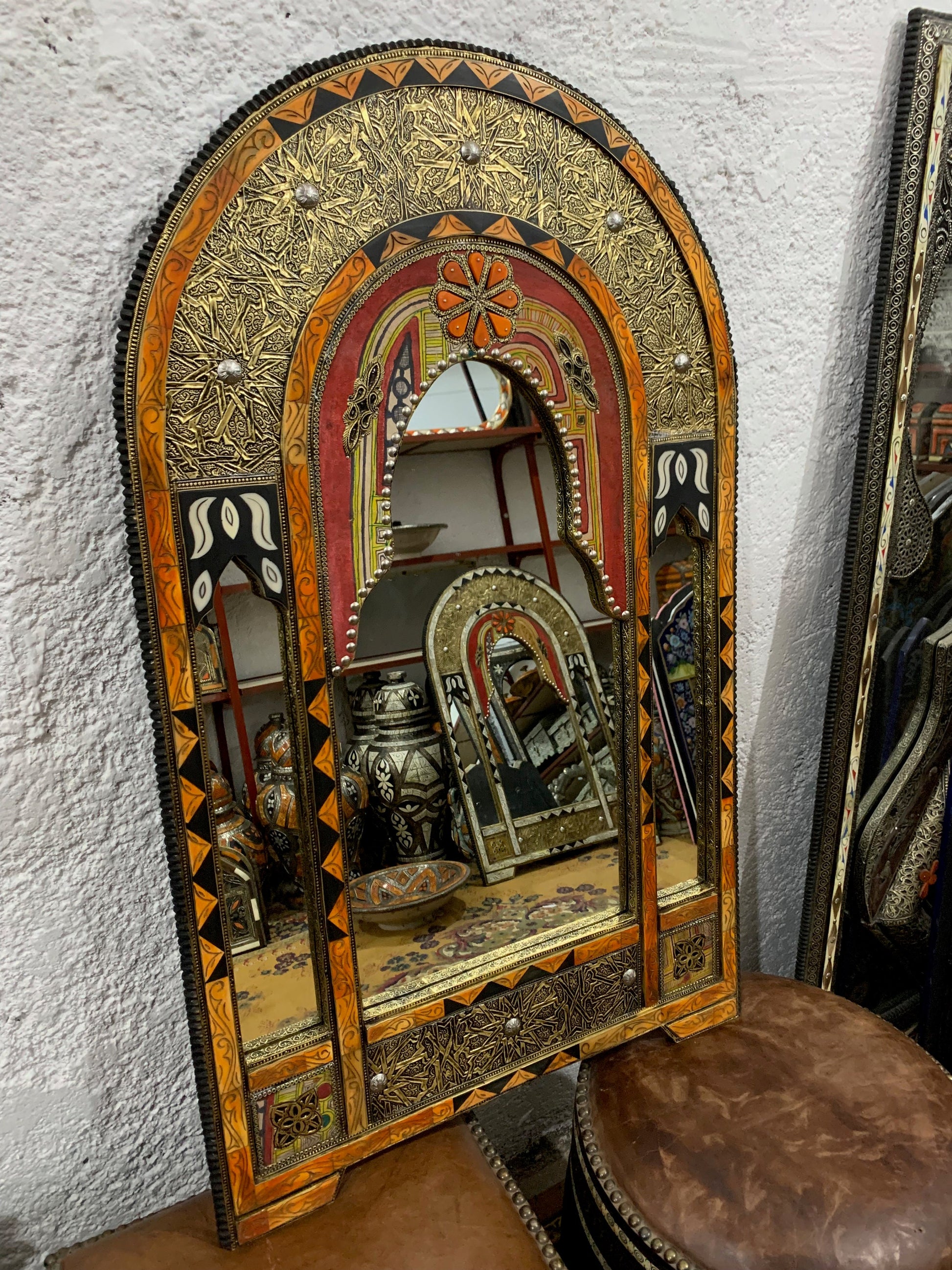 a mirror sitting on top of a table next to a stool