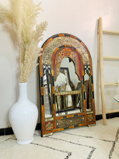 a white vase sitting next to a mirror on a floor