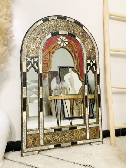 a mirror sitting on top of a table next to a ladder