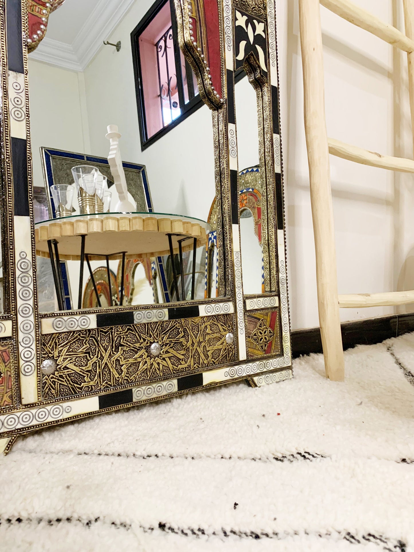a mirror sitting on top of a table next to a ladder
