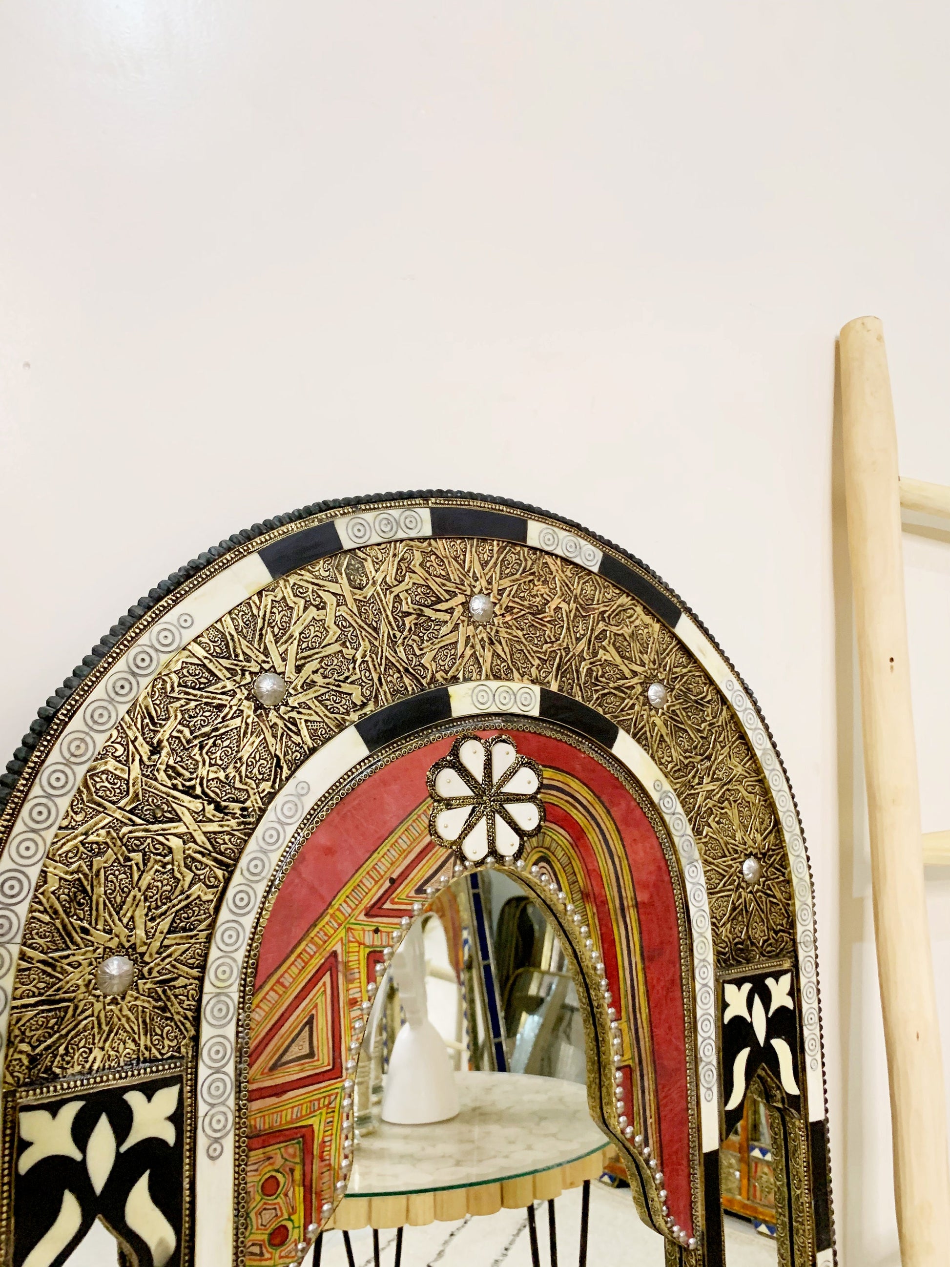 a mirror sitting on top of a wooden shelf