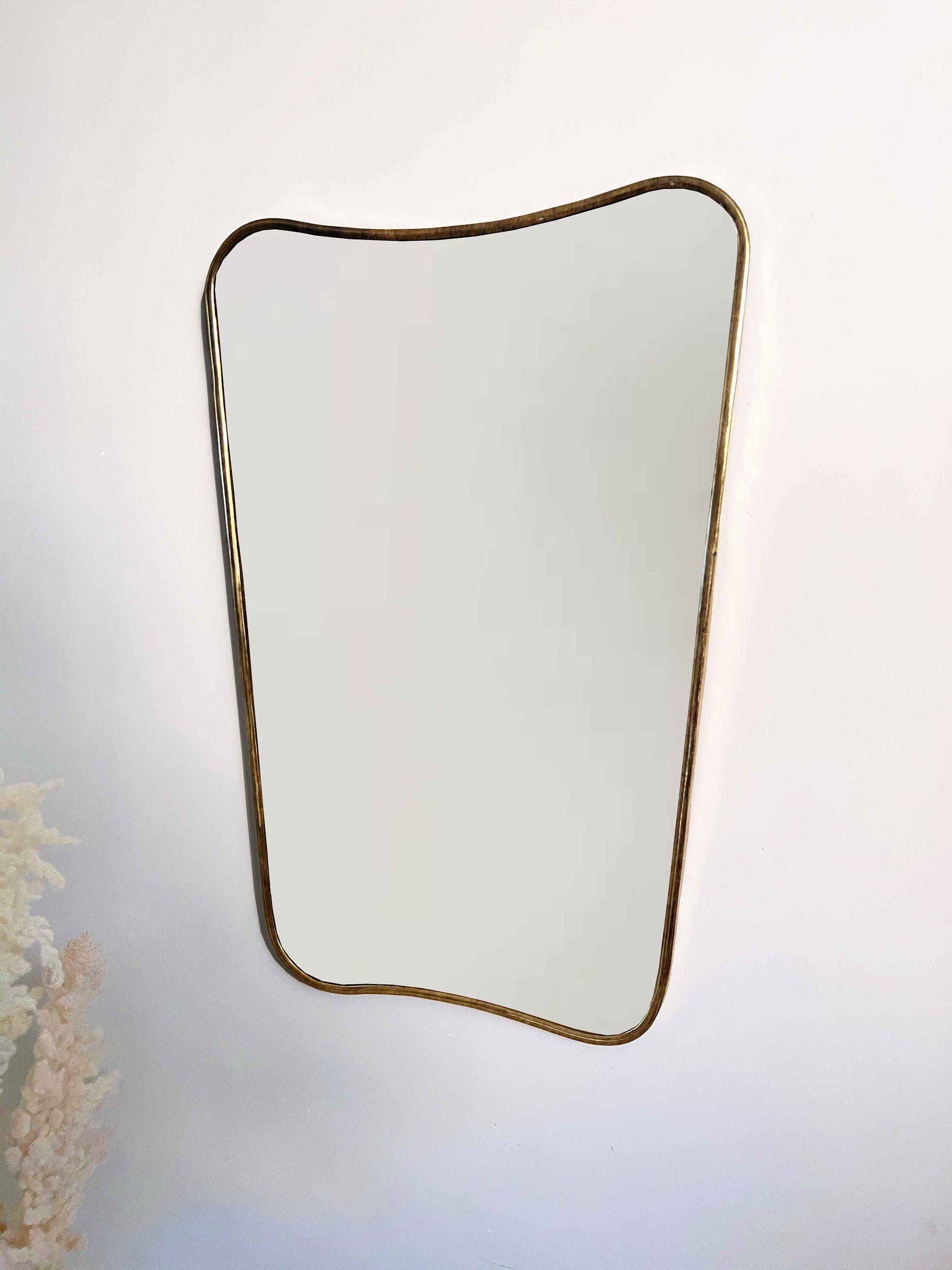 a mirror hanging on a wall next to a vase