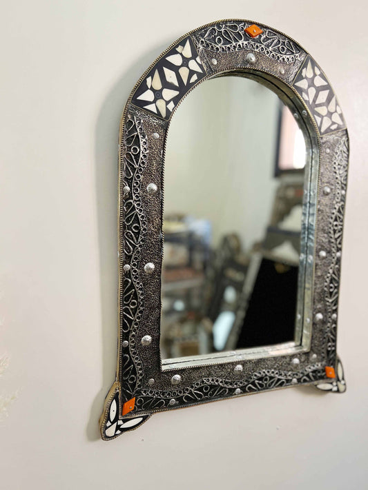 a mirror hanging on a wall next to a table