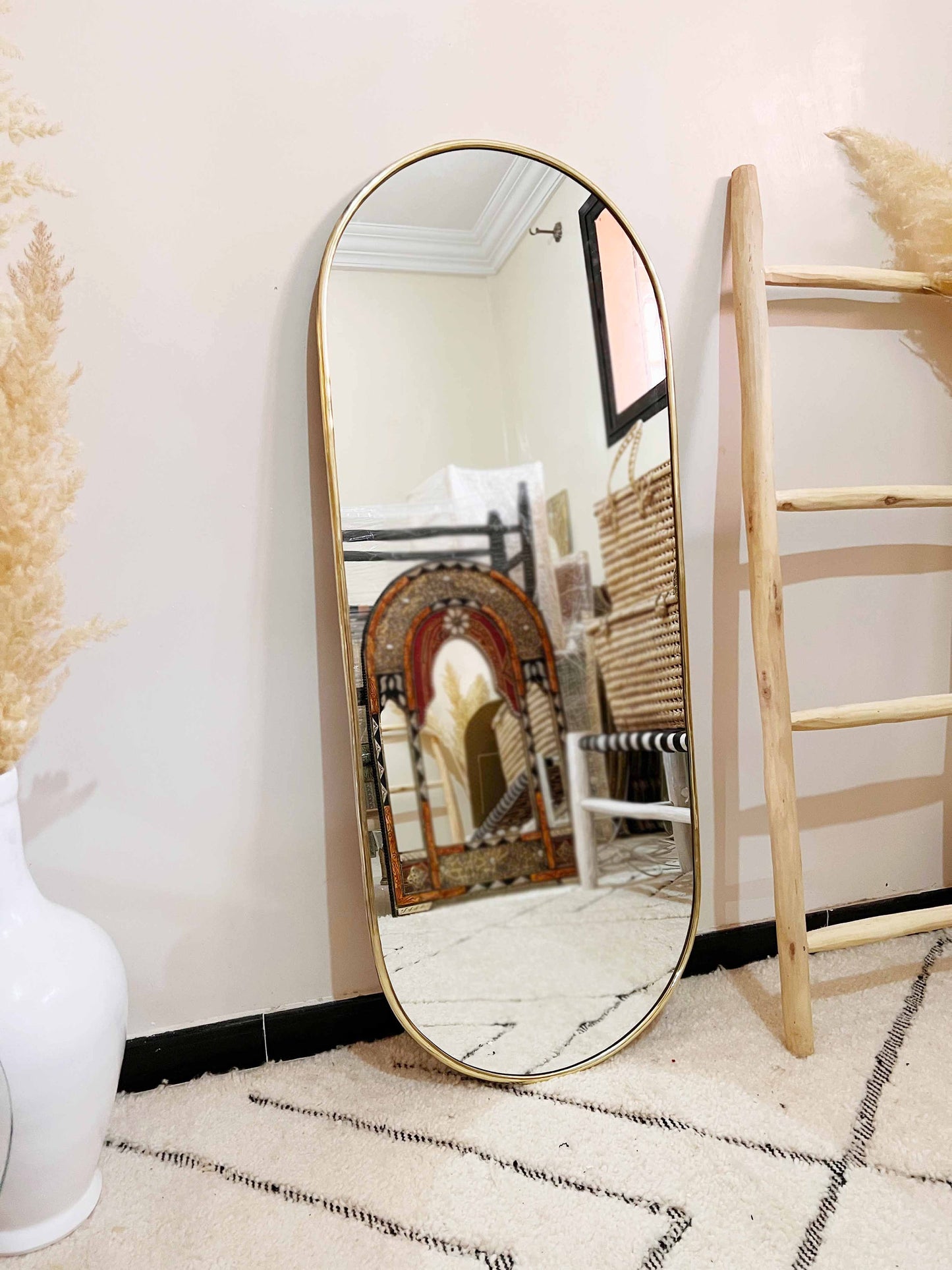 a mirror sitting on the floor next to a ladder