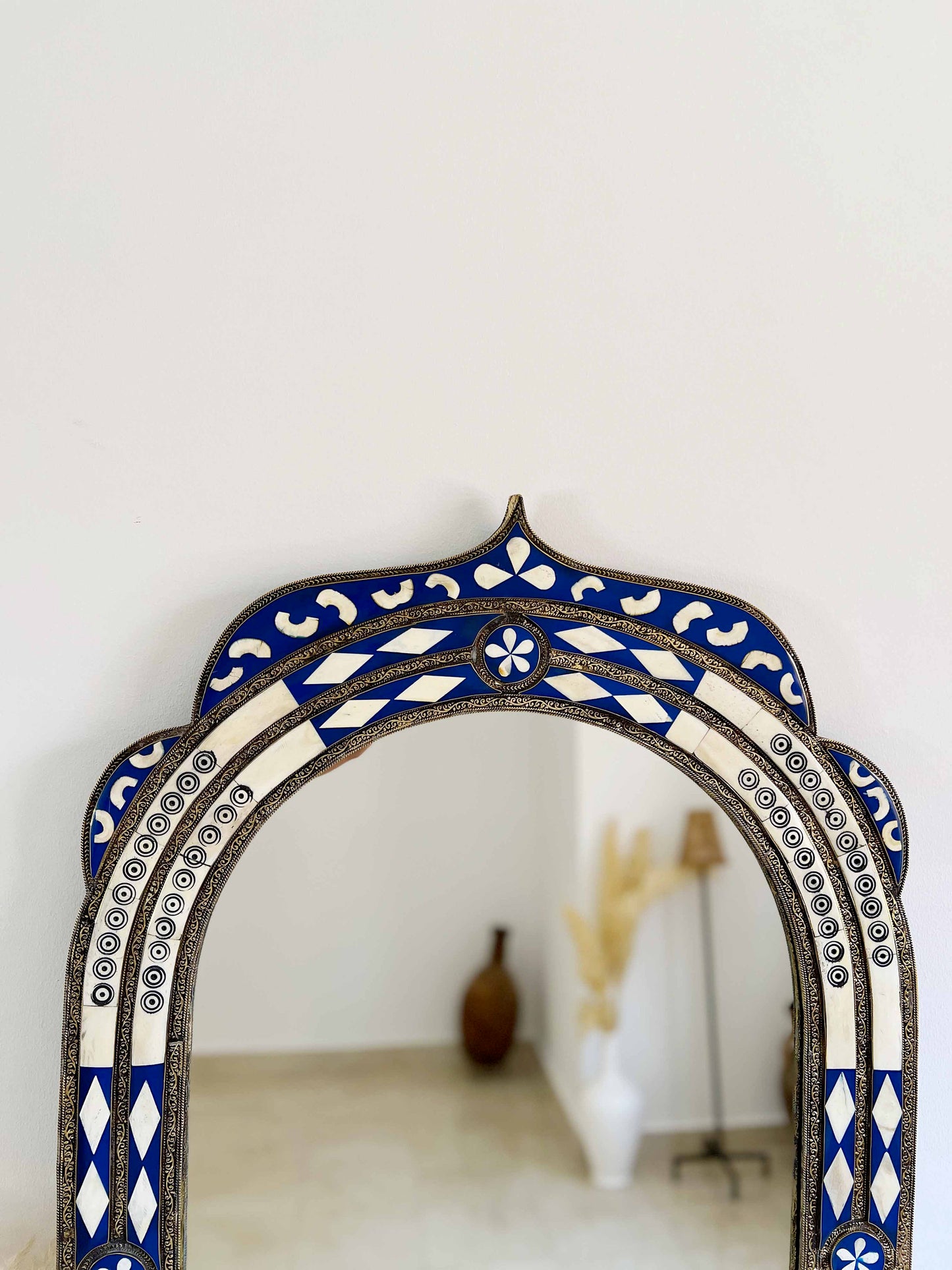 a blue and white mirror sitting on top of a table