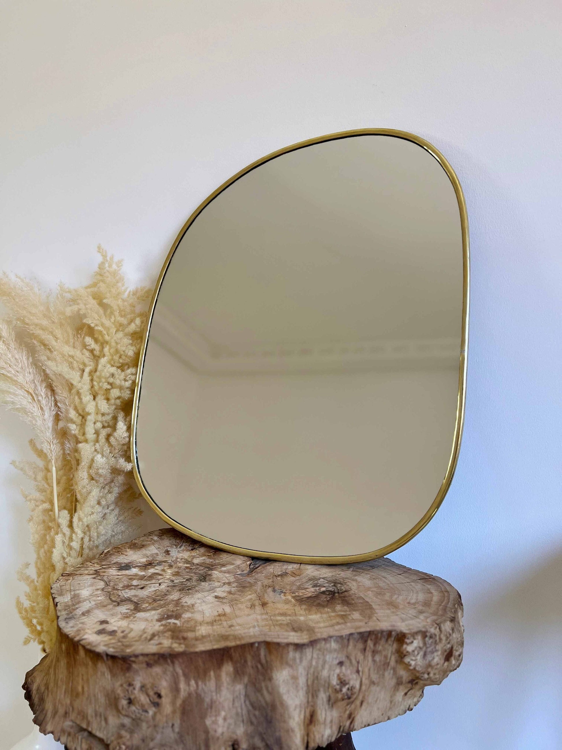 a mirror sitting on top of a piece of wood