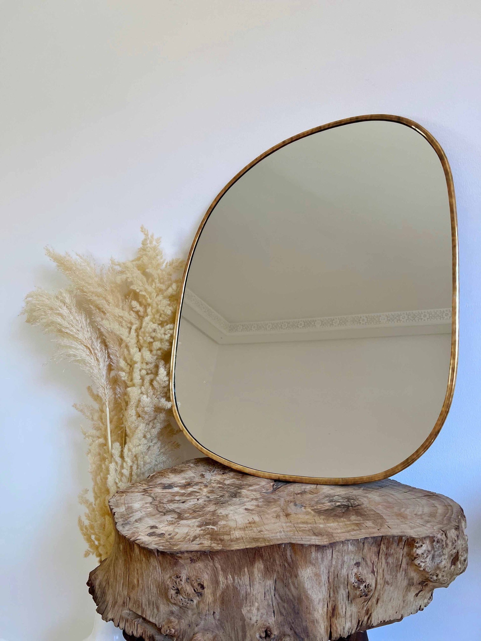 a mirror sitting on top of a wooden stump