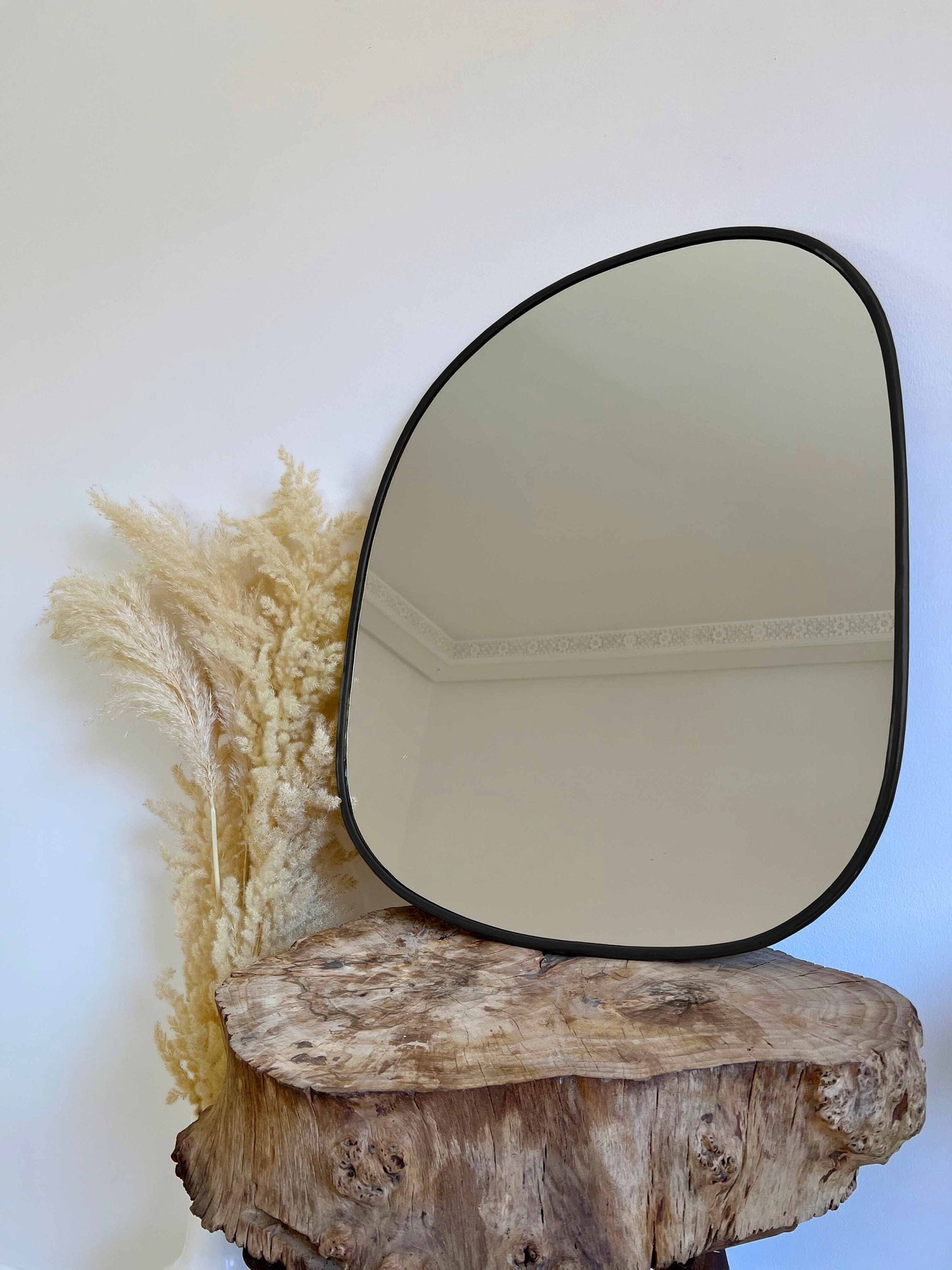 a mirror sitting on top of a wooden stump