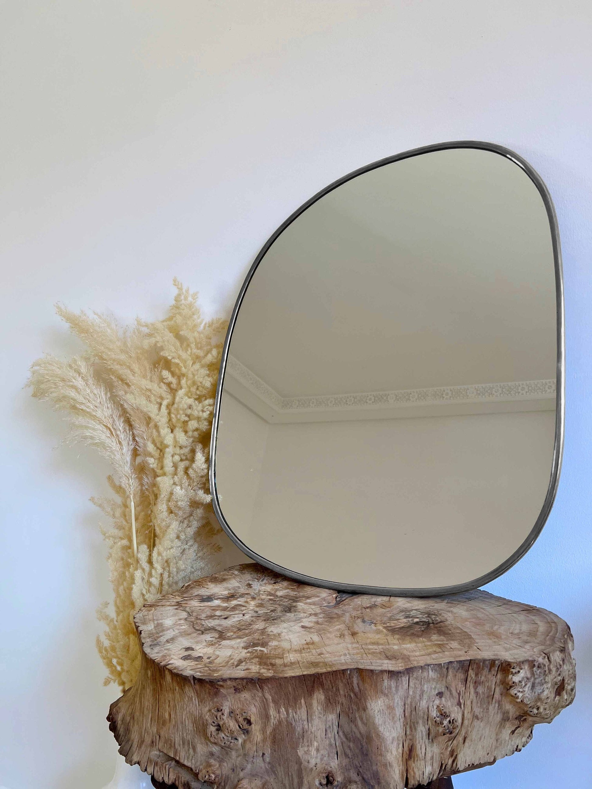 a mirror sitting on top of a wooden stump