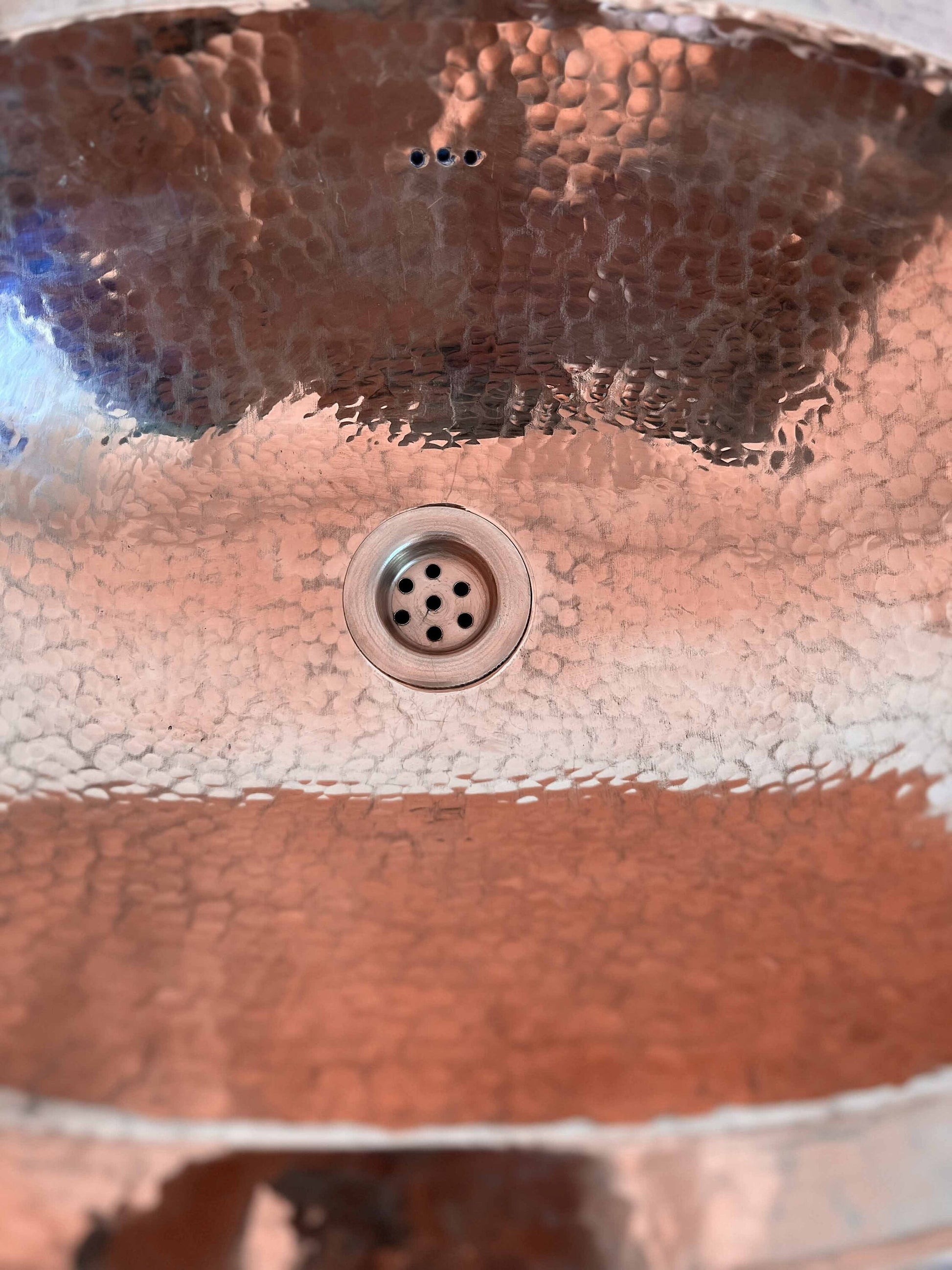 a close up of a metal sink with a drain