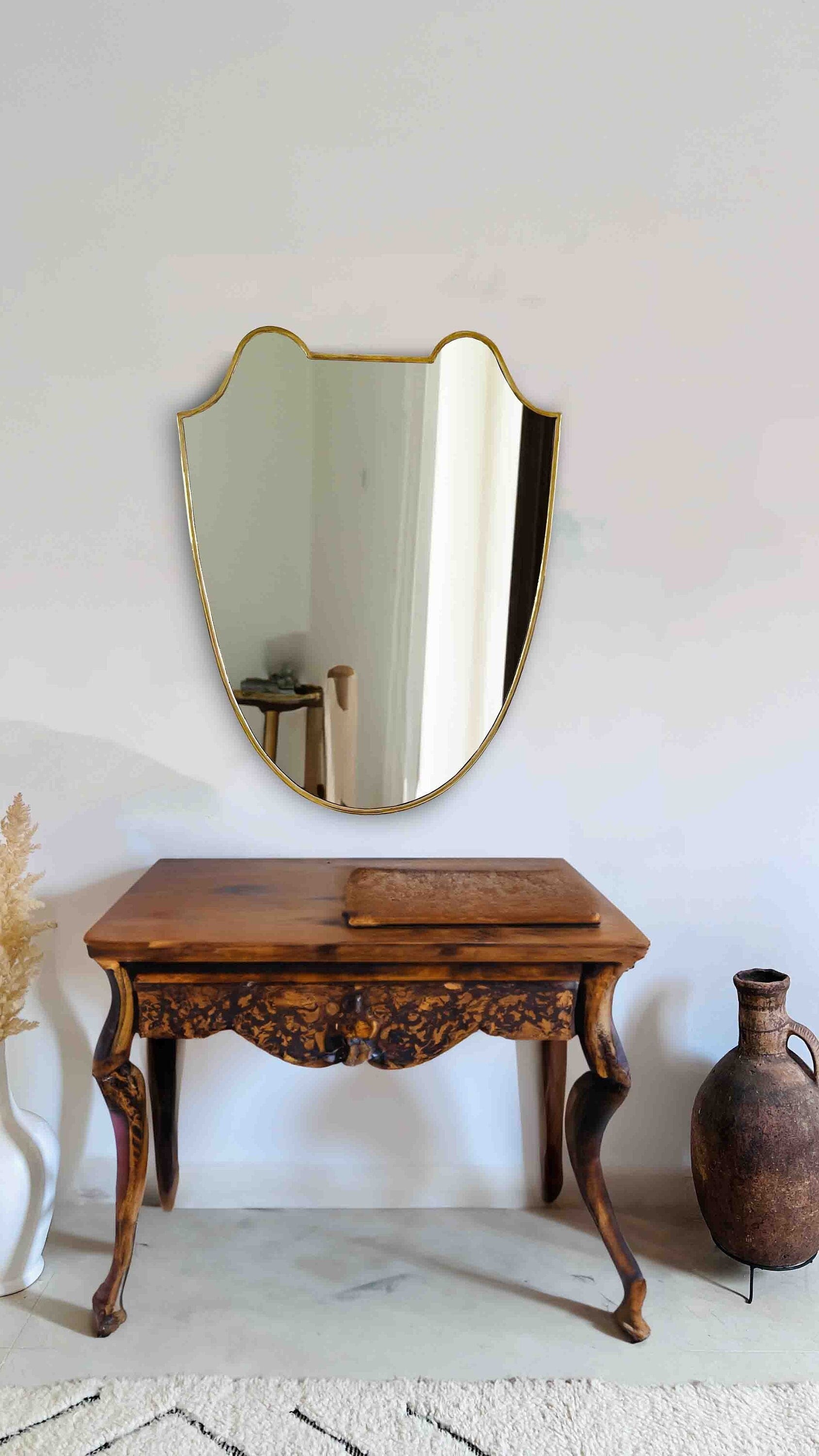 a wooden table with a mirror on the wall
